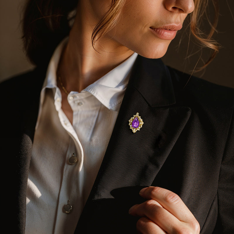 Amethyst and diamond teardrop pin on dark lapel, 14kt yellow gold with halo
