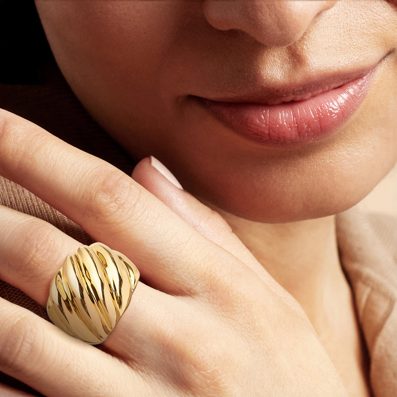 Gold-plated shrimp-shaped ring worn on finger; glossy ridged band