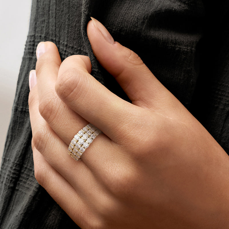 Three-row diamond band ring in 18kt yellow gold worn on finger