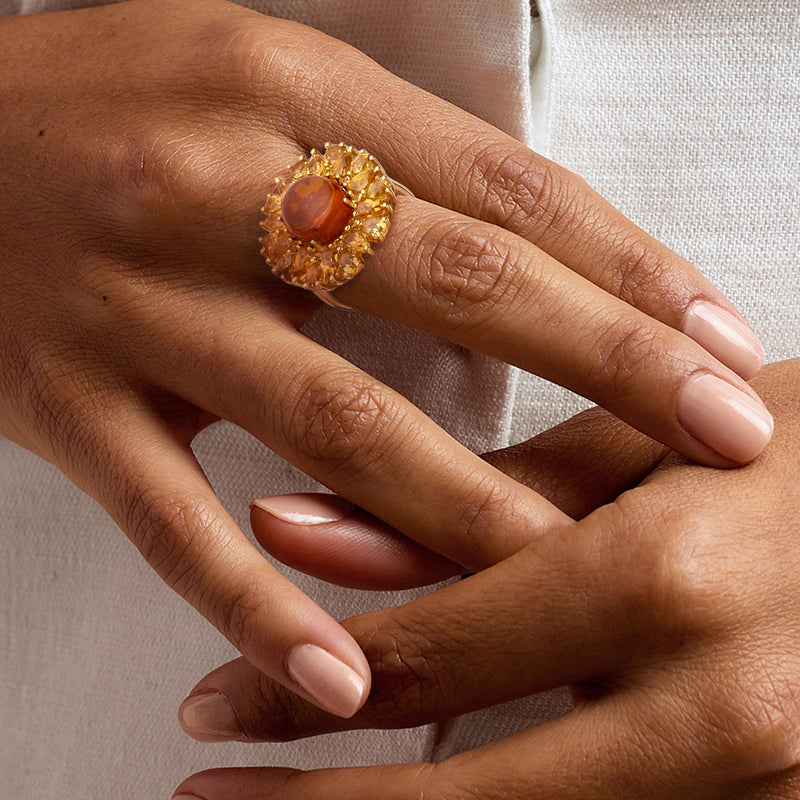 Amber cabochon citrine ring on hand, yellow gemstone halo in gold over sterling