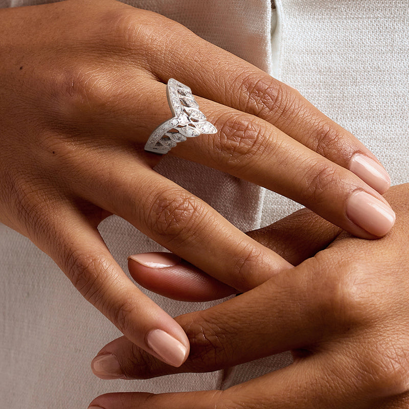 14kt white gold diamond cluster ring worn on hand with oval center and small side stones