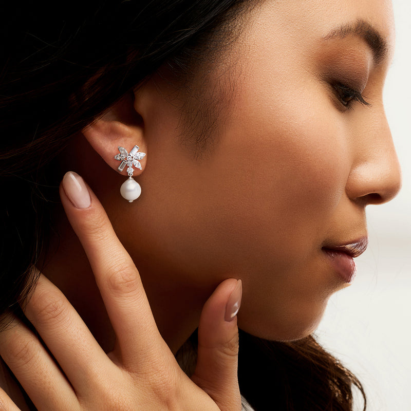 Rhodium-plated baroque pearl drop earrings with CZ floral studs, worn on model