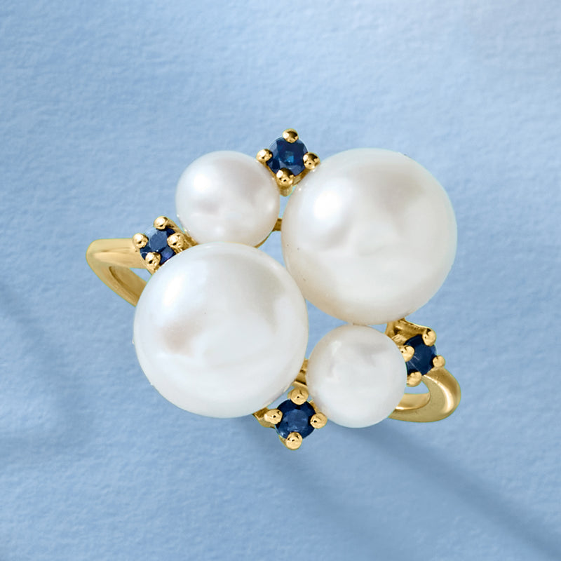 Gold-tone pearl ring with four white pearls and small blue sapphire clusters