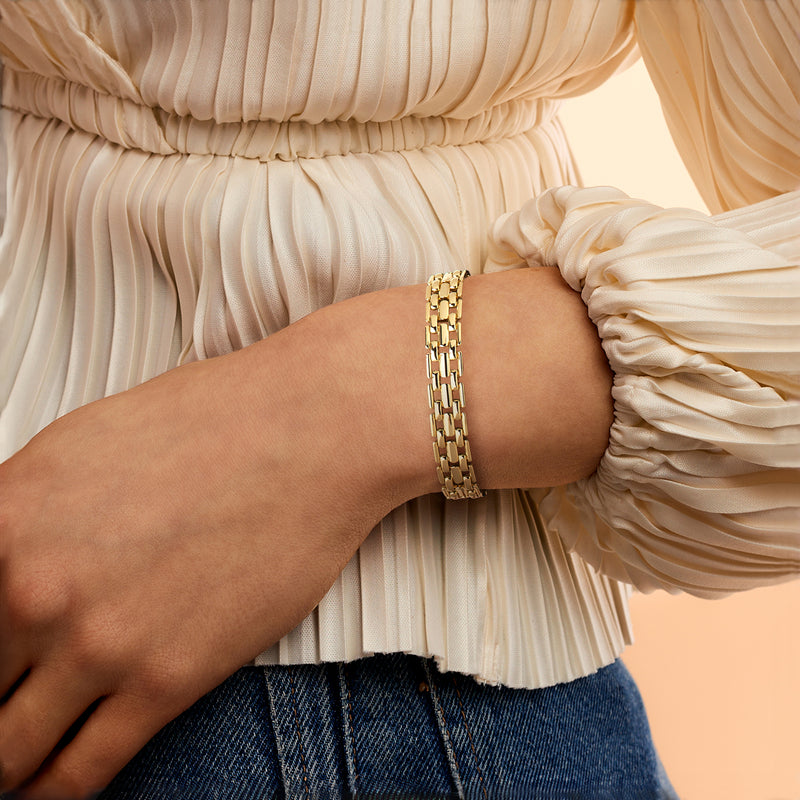 Gold-plated chain bracelet worn on wrist with flat link pattern