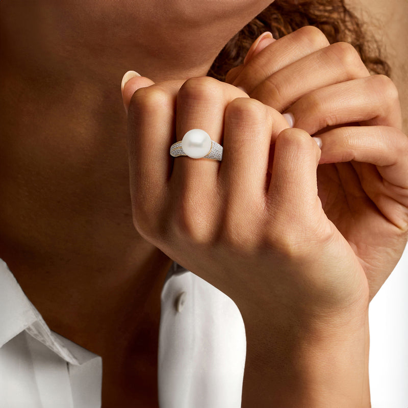 Cultured pearl and diamond ring on hand, yellow gold with white pearl