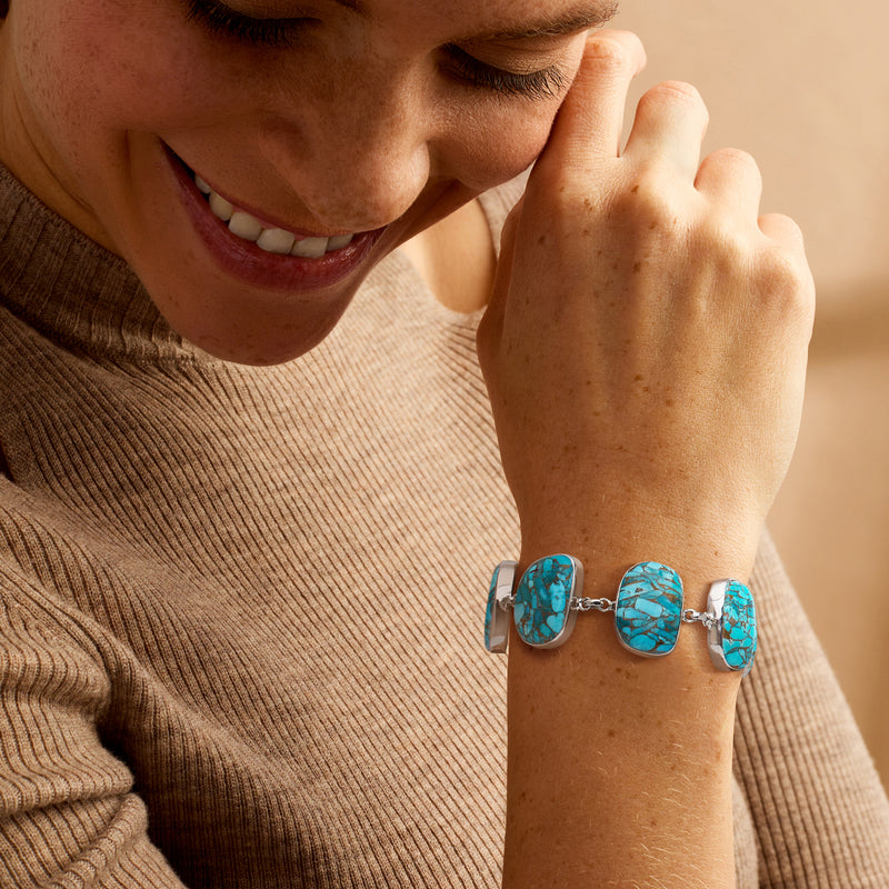 Turquoise stone link bracelet in sterling silver worn on wrist