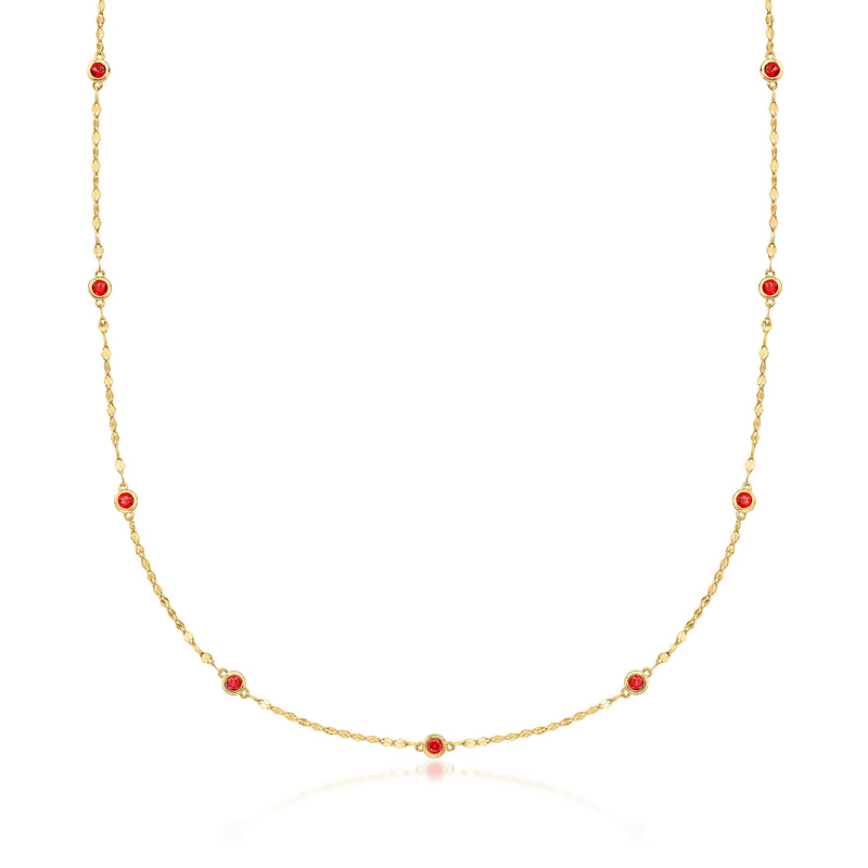 Gold-tone station necklace with round red bezel-set garnets along chain