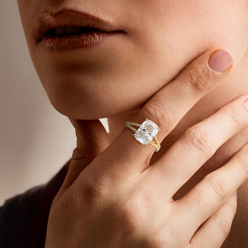 14kt yellow gold solitaire diamond ring on hand, cushion-cut center stone
