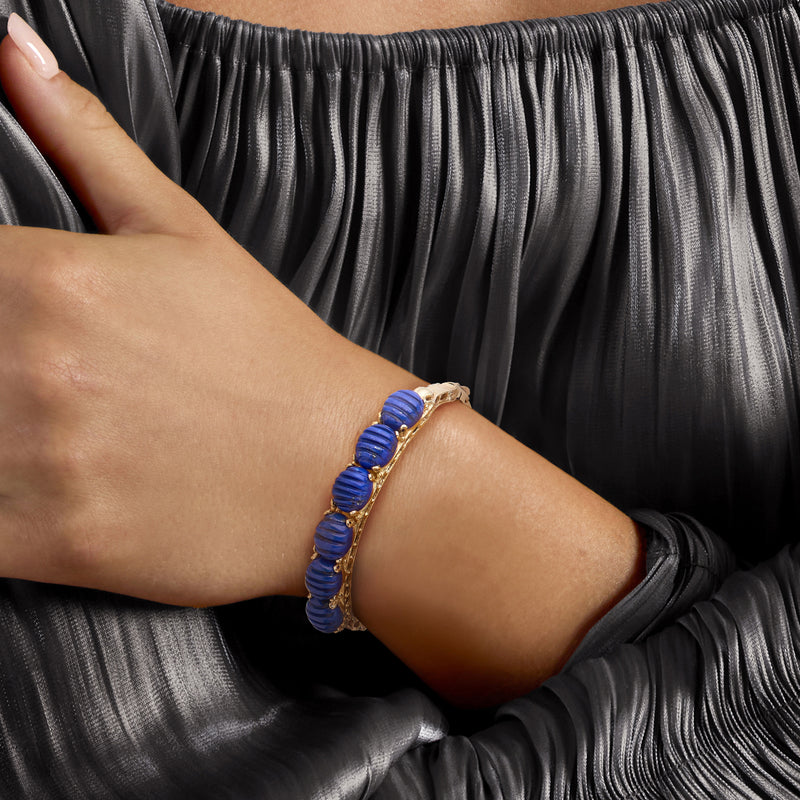 Lapis blue disc bangle bracelet in 14kt yellow gold on wrist
