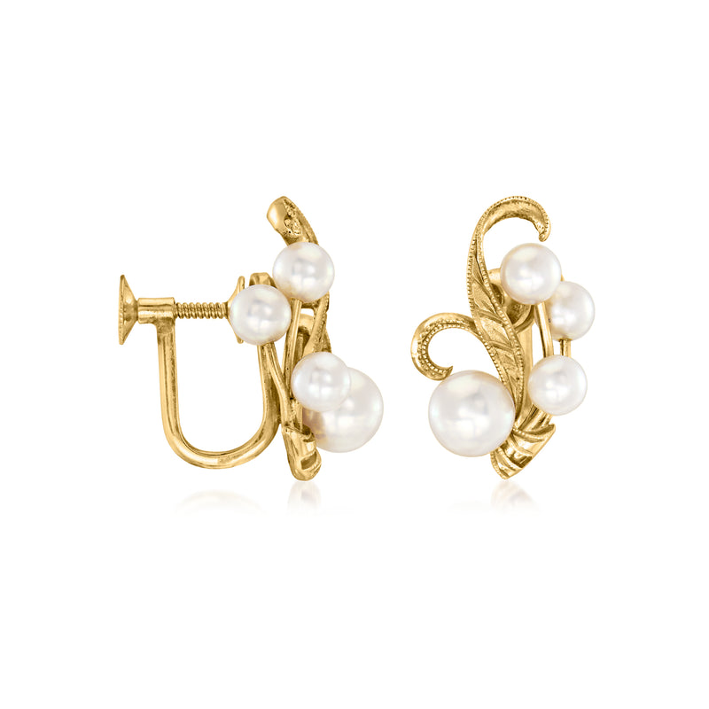 Gold-tone clip earrings with white pearls arranged in a swirling leaf design