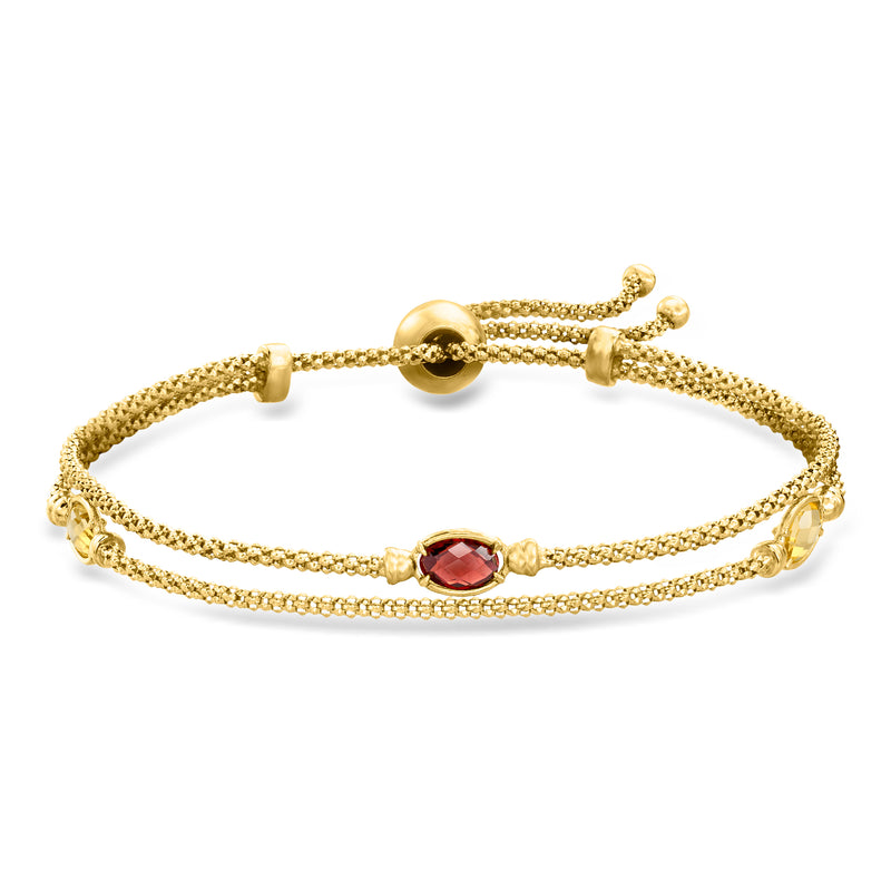 Gold bolo bracelet with layered chain and oval red gemstone center