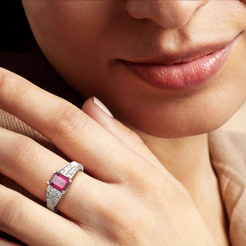 Rhodolite and diamond ring on finger, square red center with textured metal band