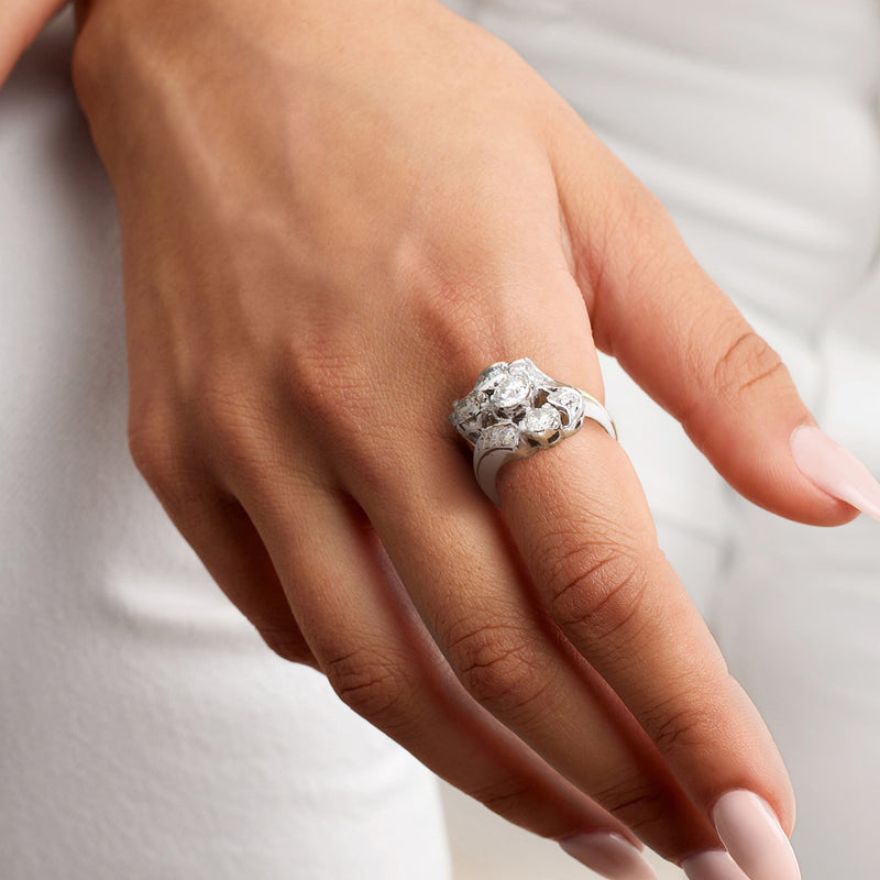 Diamond cluster ring on hand with round stones set in white gold band
