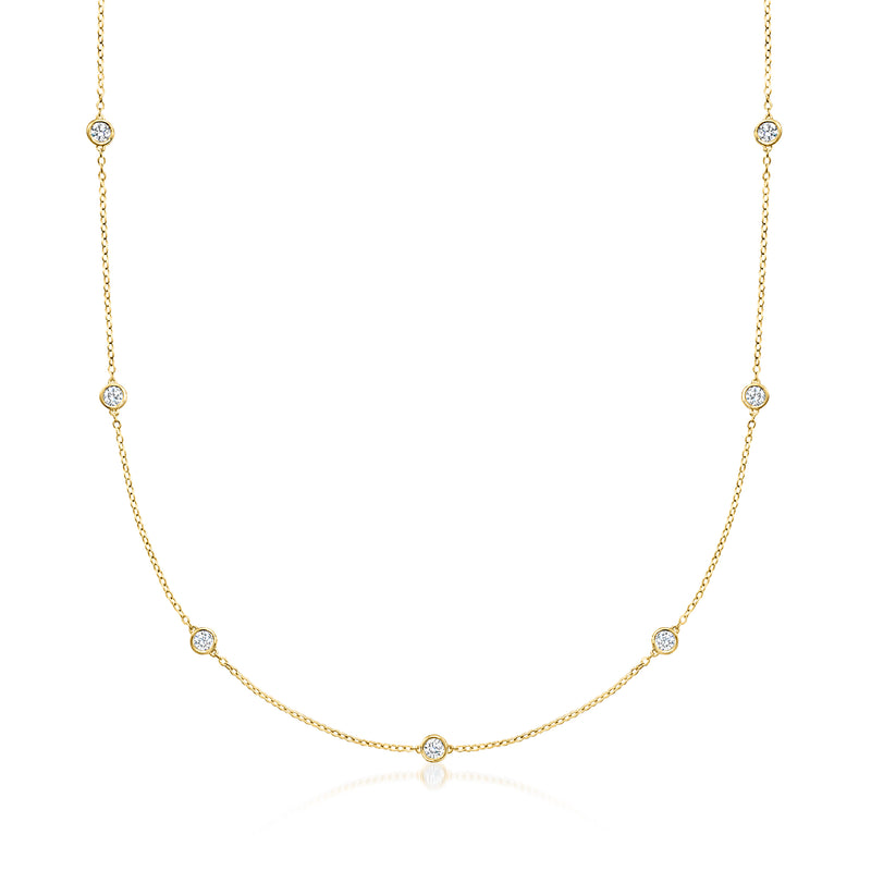 Gold station necklace with round bezel-set diamond accents in a curved row