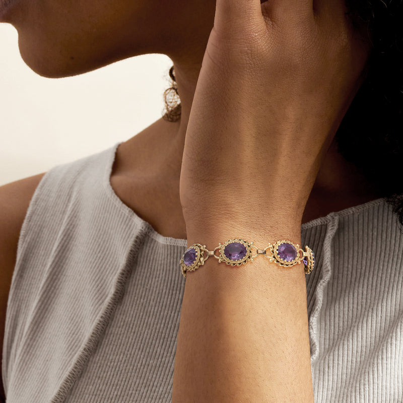 Amethyst link bracelet in yellow gold with oval purple stones on wrist