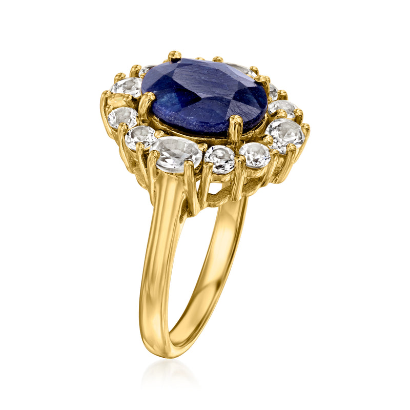 Gold ring with large oval blue gemstone and white crystal halo, side view