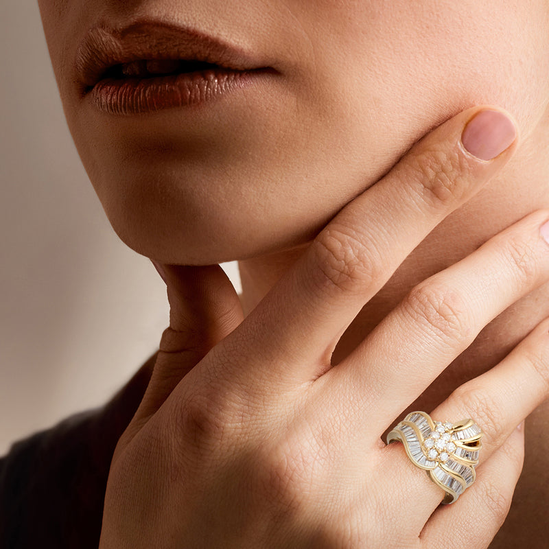 Diamond ring on finger with baguette band and round cluster, 18kt yellow gold