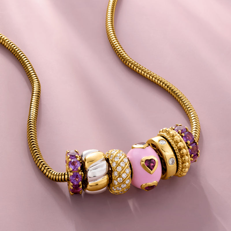 Gold bead charm with purple gemstone details and heart-shaped accents