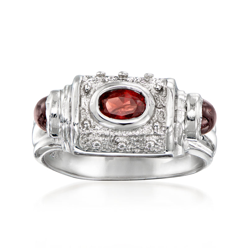 Oval red garnet ring in 14kt white gold with textured bezel and halo border