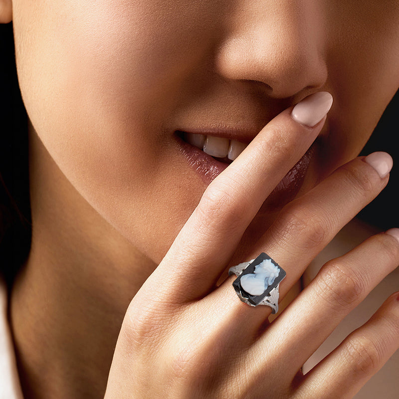 Vintage black cameo ring on finger, white profile stone in filigree white gold setting