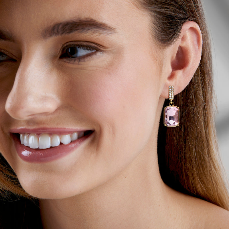 Gold-plated drop earrings with pink square stone and clear pave detail on ear