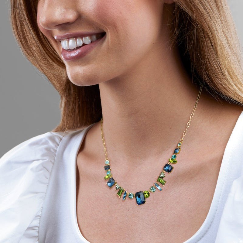 Gold-plated necklace worn on model with blue and green square gemstone geometric links