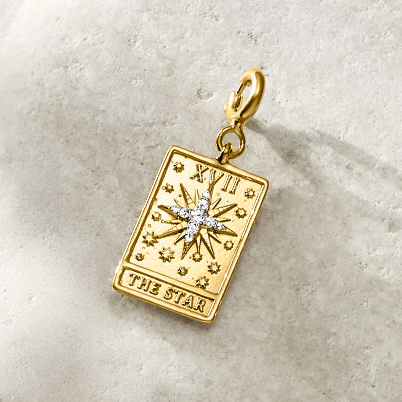 Gold tarot card charm with starburst motif, diamond accents, and “THE STAR”