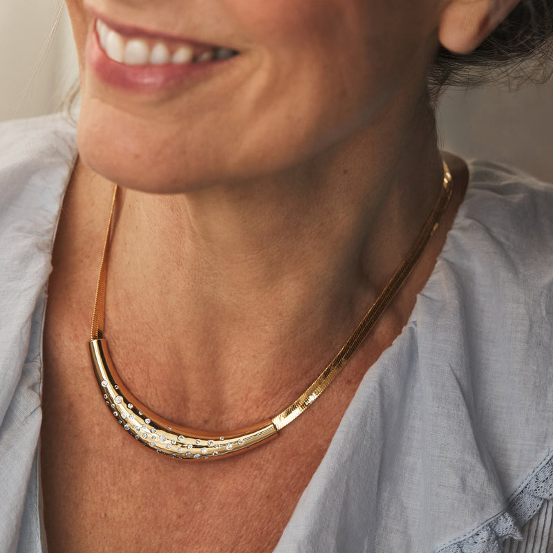 Yellow gold-plated herringbone necklace with CZ accents on model