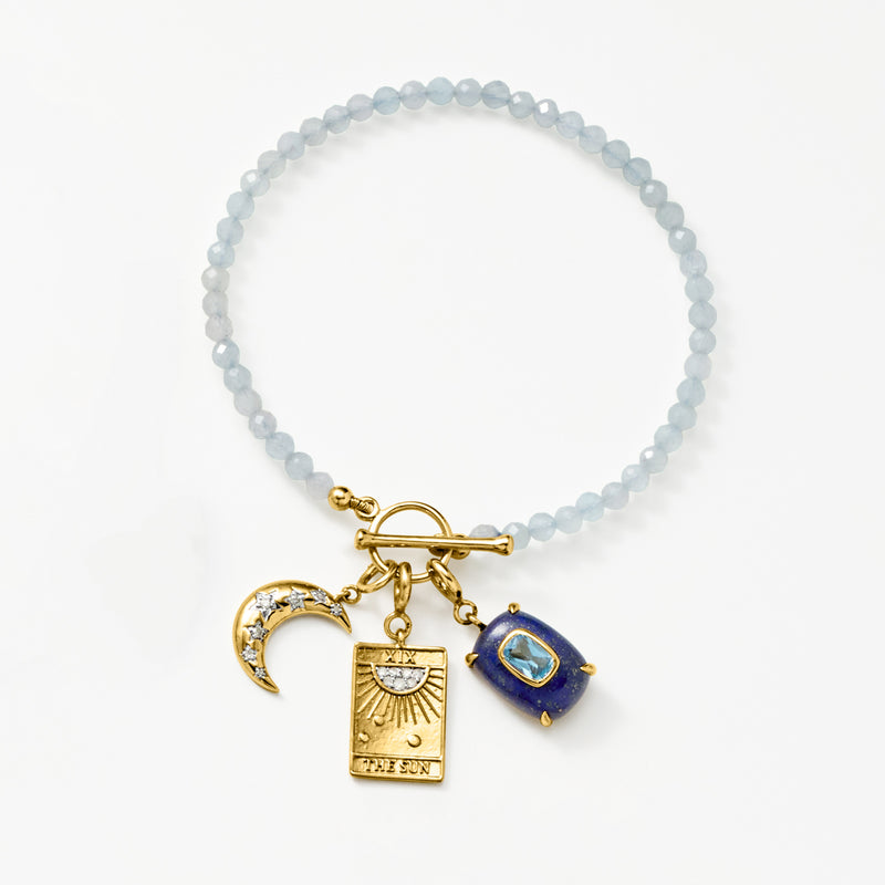 Gold sun charm with diamonds on a beaded bracelet
