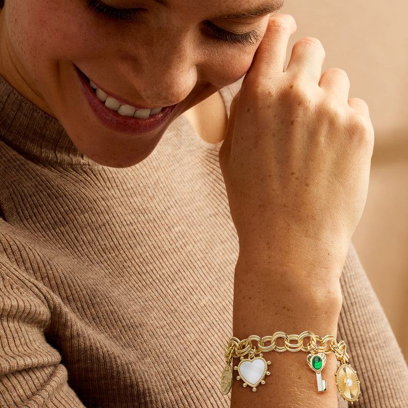 Gold-plated charm bracelet with heart links, green gem, and blue enamel heart charm
