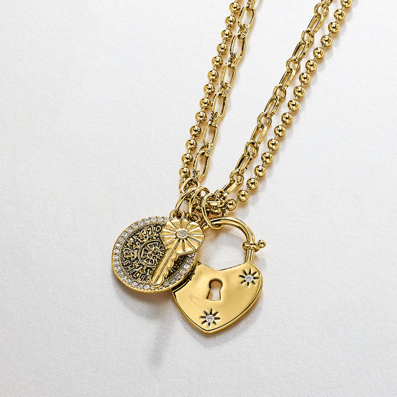 Gold-plated heart lock charm necklace with key and round coin charm on chain