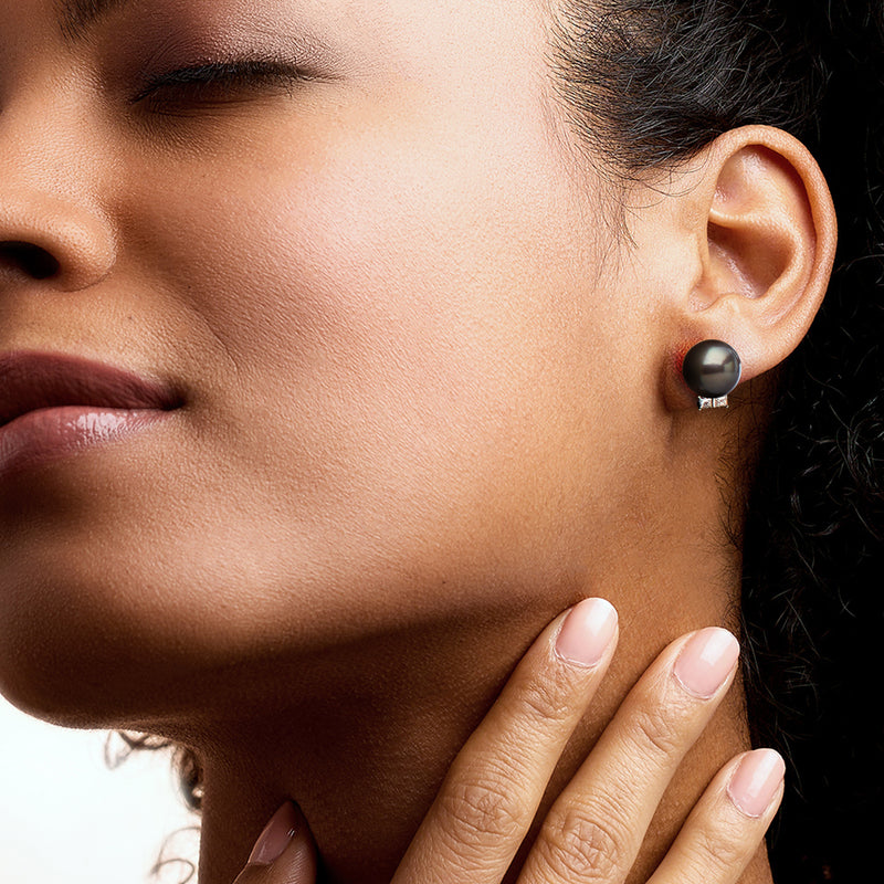 Black pearl post earrings with diamond cluster on ear, white-gold setting