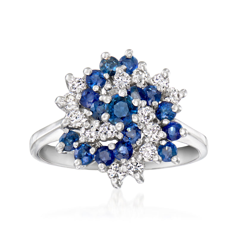 White gold cluster ring with blue sapphires and clear diamonds, swirling flower design