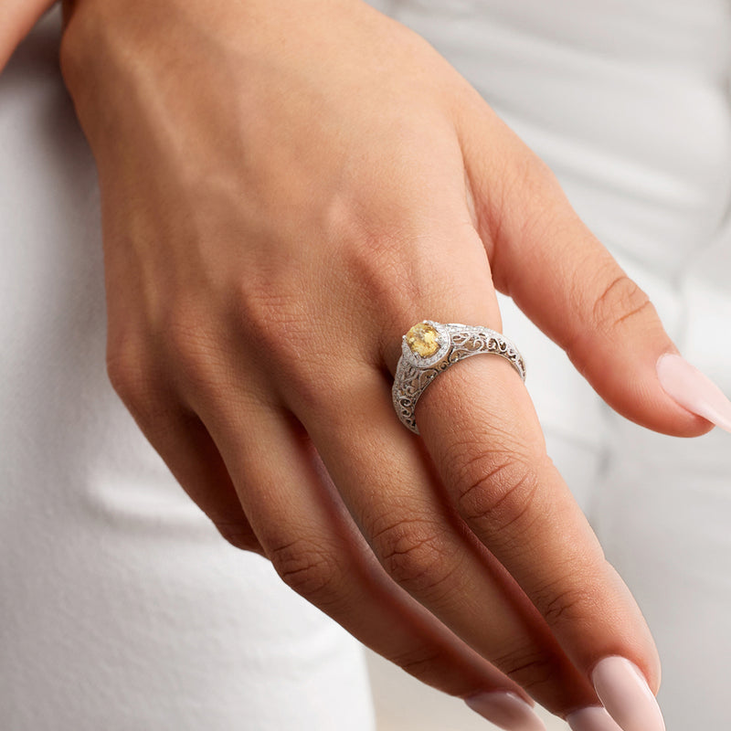 Citrine and diamond vintage ring worn on hand, oval yellow stone in white gold filigree