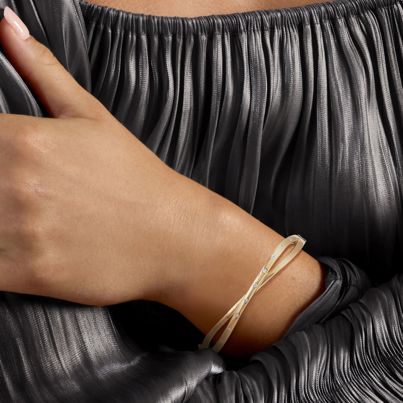 Crisscross diamond bangle bracelet on wrist, 18kt gold over sterling with round stones