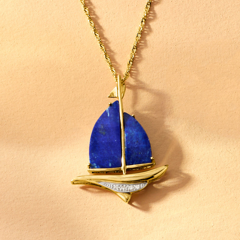 Gold sailboat pendant necklace with blue lapis sail and diamond-detailed base