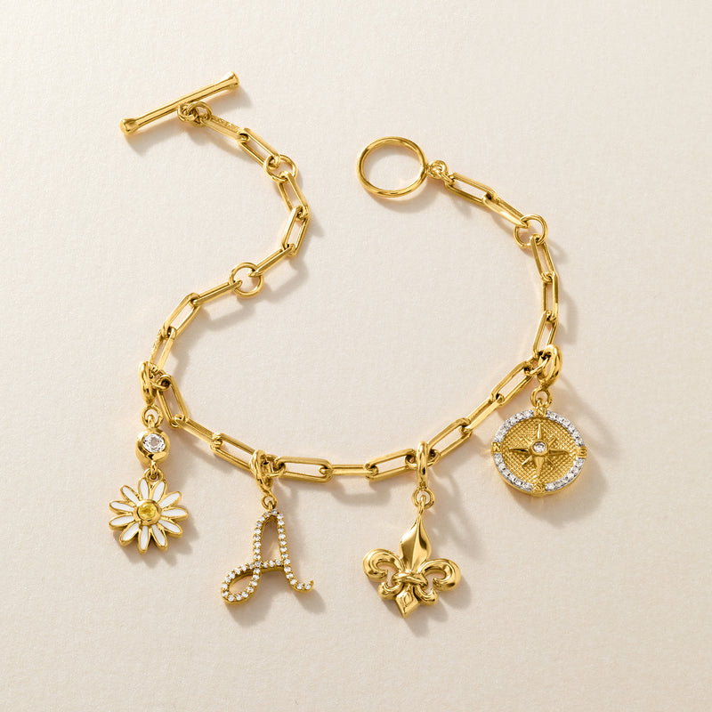 Gold-tone charm bracelet with chain links and small flower, initial, and locket charms