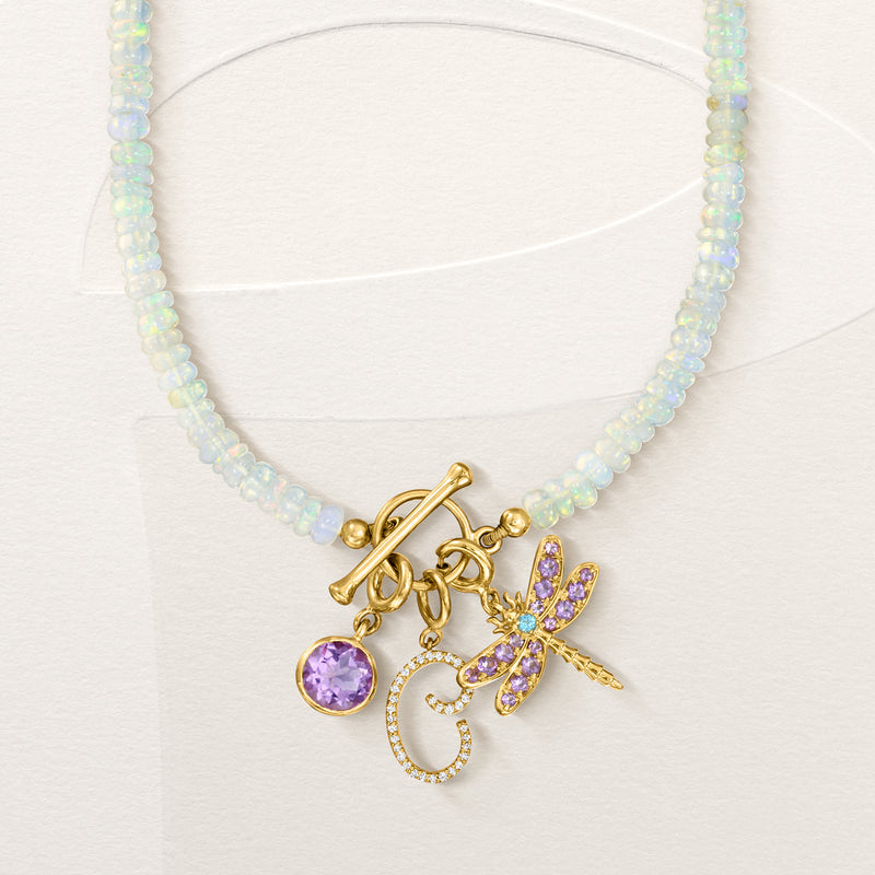 Gold dragonfly charm with purple stones and blue center on pale blue beaded necklace