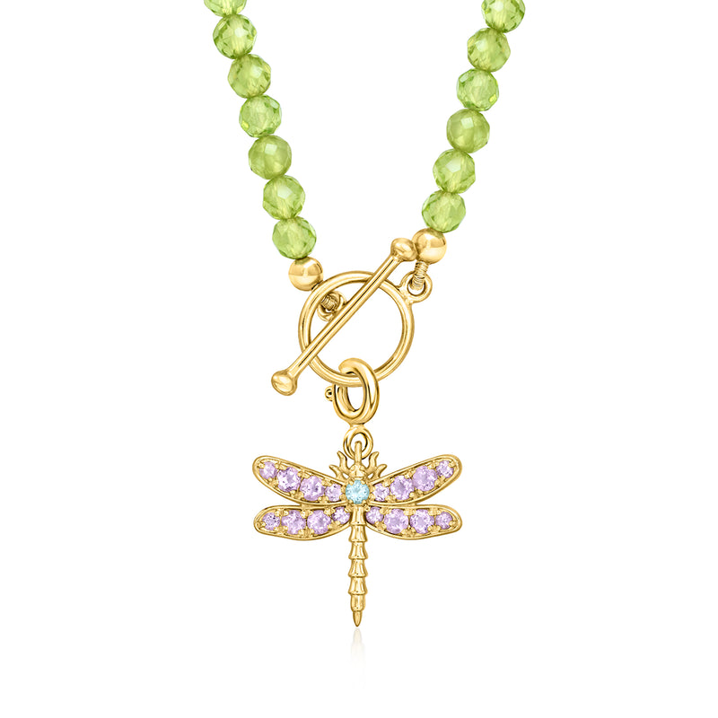 Gold dragonfly pendant with purple wing stones and blue center, on green bead strand