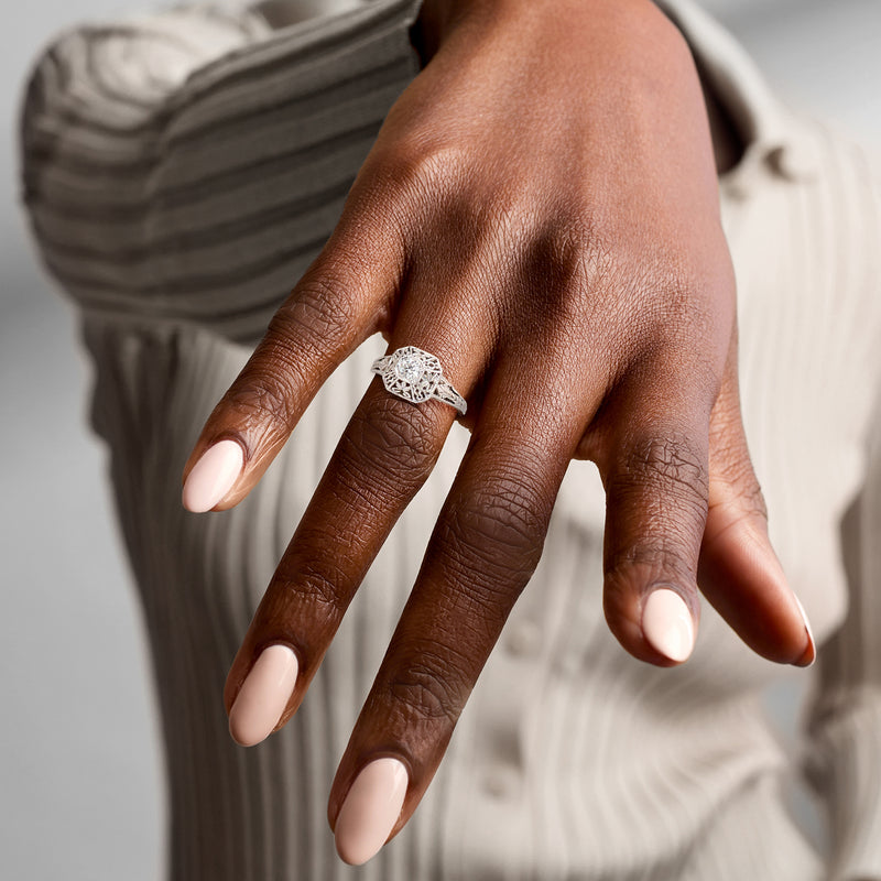 14kt white gold openwork diamond ring with round center stone on a hand