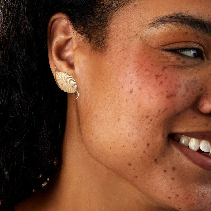 Gold leaf clip earring on ear, ribbed leaf design