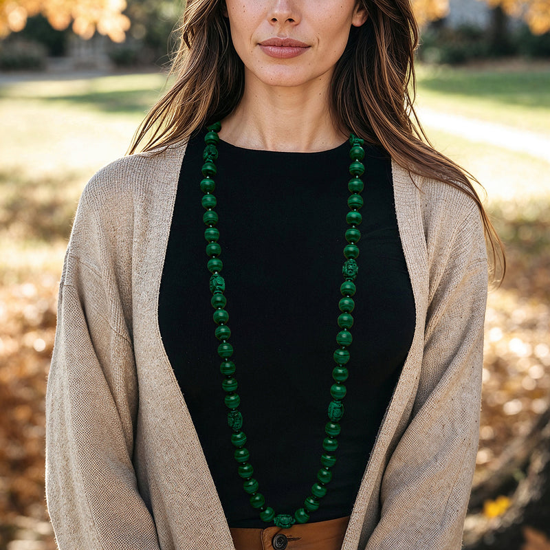 Green malachite beaded necklace worn with a dark top and light cardigan