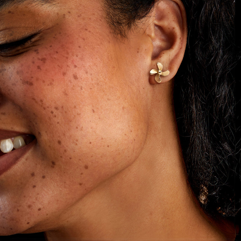 14kt yellow gold propeller stud earrings on model ear