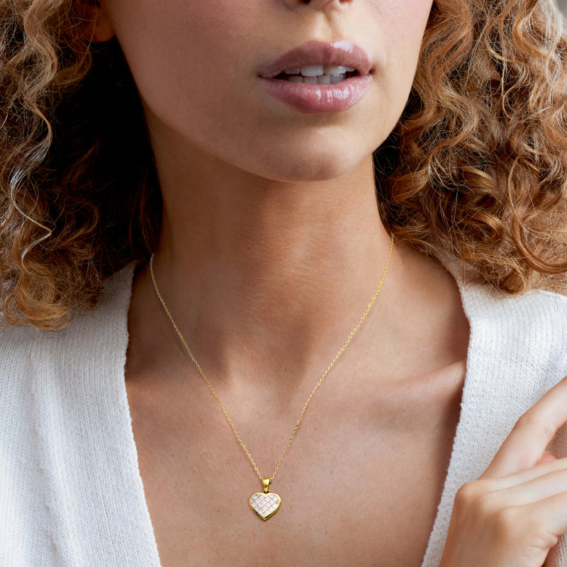 Worn yellow gold heart diamond pendant necklace on fine chain with small sparkle