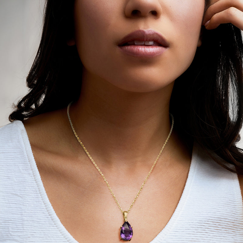 Yellow gold chain necklace with teardrop amethyst pendant, worn