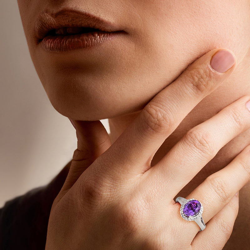 Sterling silver amethyst and white topaz oval halo ring on finger