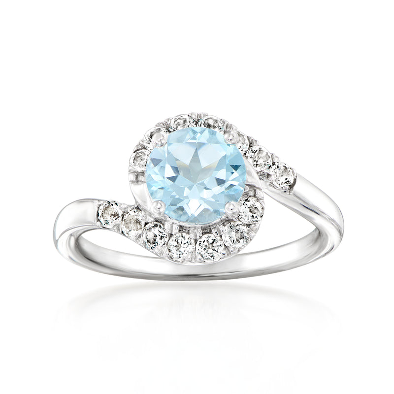 Sterling silver ring with sky blue topaz oval center and white stone halo swirl