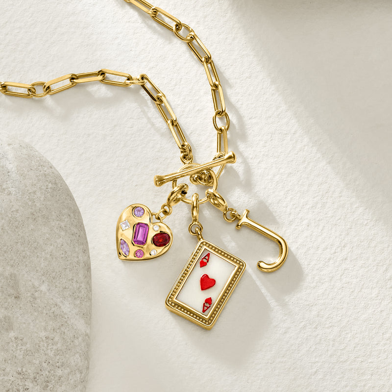 Gold charm necklace with gem heart charm and playing-card charm, with toggle clasp