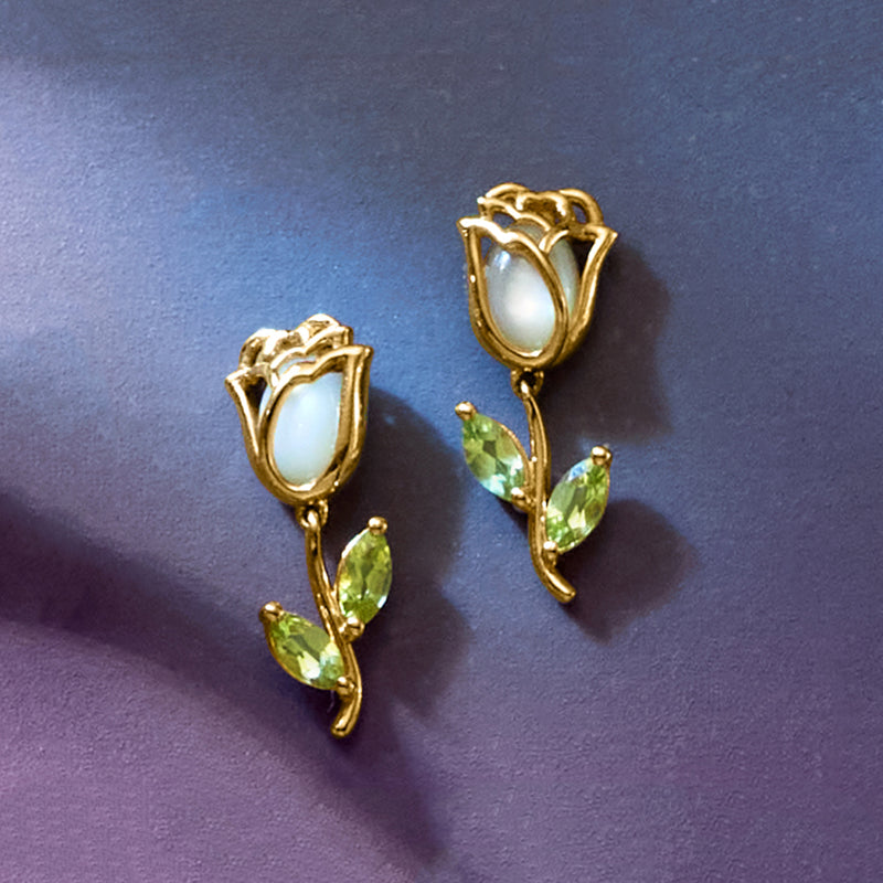 Gold drop earrings featuring mother-of-pearl center petals and green peridot accents