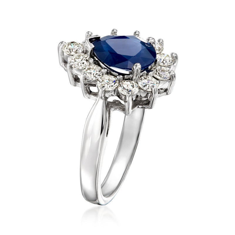 White gold ring with oval deep blue sapphire and sparkling round diamond side clusters